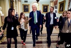 FILE - Senate Majority Whip Sen. John Cornyn, R-Texas, speaks to reporters as he walks to the Senate Chamber at the Capitol in Washington, Jan. 22, 2018.