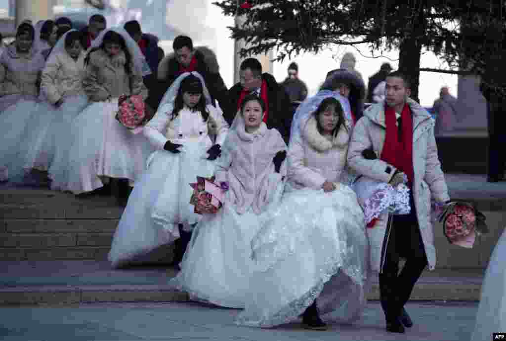 Couples arrive for a &quot;mass ice and snow wedding&quot; ahead of the opening of the Harbin International Snow and Sculpture Festival in Harbin, in China&#39;s northeast Heilongjiang province.