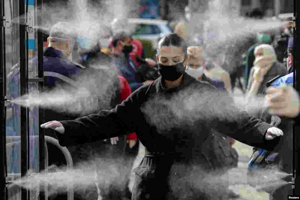 People are disinfected before entering a market, as officials take measures to stop the spread of the coronavirus disease (COVID-19), in Tirana, Albania.