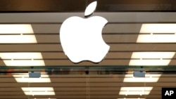 ເຄື່ອງໝາຍ ຫລື ໂລໂກຂອງ Apple ທີ່ຕິດຢູ່ຂ້າງເທິງຂອງທາງເຂົ້າຮ້ານຄ້າແຫ່ງນຶ່ງ ໃນເມືອງ Dallas ລັດ Texas ໃນວັນທີ 19 ກັນຍາ 2013. 