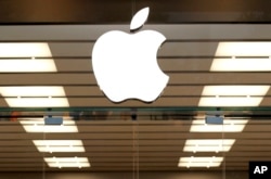 FILE - The Apple logo is seen above a store entrance, in Dallas, Sept. 19, 2013.