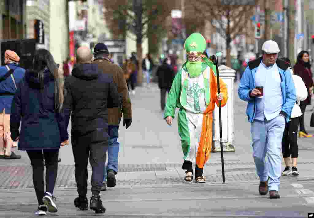 A man dressed as St Patrick walks down O'Connell street in Dublin, Ireland. St Patrick's Day parades across Ireland were canceled for the second year because of the COVID-19 pandemic.