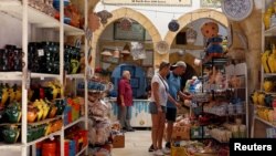 FILE - Russian tourists are seen shopping at the old medina in Sousse, Tunisia, Sept. 30, 2017.