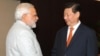 Indian Prime Minister Narendra Modi (L) shakes hands with Chinese President Xi Jinping during the BRICS summit in Fortaleza, Brazil, In this photograph received from the Press Information Bureau (PIB) and taken on July 14, 2014, 