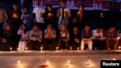 People hold lit candles for the victims of an explosion in Kabul, Afghanistan, June 1, 2017. 