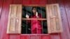 Former garment factory worker Channa Prak, 20, who is an acid attack victim, looks out of a window at a secure shelter run by non-profit organization "Cambodia Acid Survivors Charity" outside Phnom Penh, July 7, 2010.