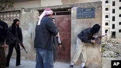 Free Syrian Army fighters take cover during fierce fighting against government troops in Idlib, north Syria, March 10, 2012.