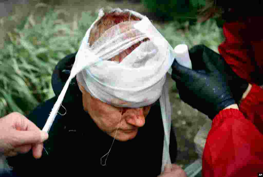 People provide a health care to a wounded protester during an opposition rally to protest the official presidential election results in Minsk, Belarus.
