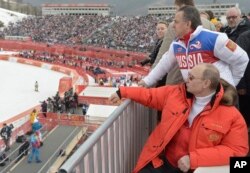 Presiden Rusia Vladimir Putin menyaksikan kompetisi ski menuruni bukit Paralimpiade Musim Dingin 2014 di distrik pegunungan Roza Khutor, Sochi, Rusia. (Foto: melalui AP)