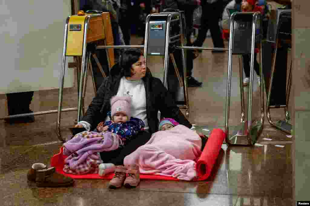 A woman with her children takes shelter inside a metro station during an air raid alert, in Kyiv, Ukraine.