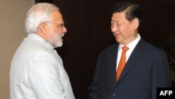 Indian Prime Minister Narendra Modi (L) shakes hands with Chinese President Xi Jinping during the BRICS summit in Fortaleza, Brazil, In this photograph received from the Press Information Bureau (PIB) and taken on July 14, 2014, 
