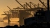 FILE - A truck arrives to pick up a shipping container near vessels moored at at the Port of Los Angeles, on Nov. 30, 2021. President Joe Biden is expected to unveil plans for substantial tariff increases on selected Chinese imports in the coming days.