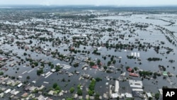 FILE - Houses are seen underwater in the flooded town of Oleshky, Ukraine, on June 10, 2023. (AP Photo, File)