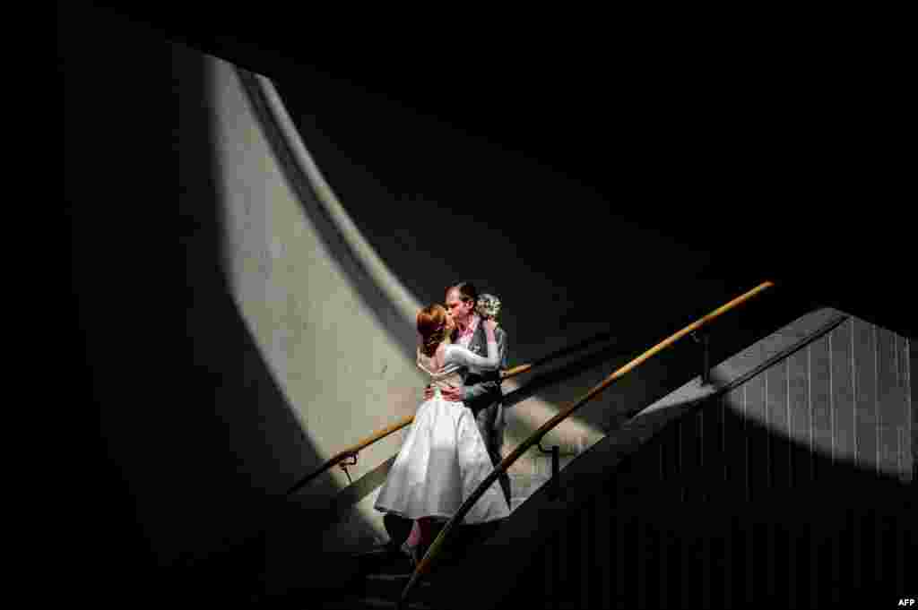 A newlywed couple kisses on the stairs of Andreyevsky Bridge in Moscow on July 7, 2020, amid the outbreak of COVID-19, caused by the novel coronavirus.