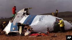 Police and investigators look at the remains of the flight deck of Pan Am 103 on a field in Lockerbie, Scotland, on December 22, 1988 (File)