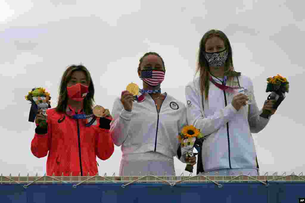 Carissa Moore, of the United States, holds the gold medal, South Africa&#39;s Bianca Buitendag holds the silver medal and Japan&#39;s Amuro Tsuzuki holds the bronze medal in the women&#39;s surfing competition at the 2020 Summer Olympics, Tuesday, July 27, 2021, at Tsurigasaki beach in Ichinomiya, Japan. (AP Photo/Francisco Seco)