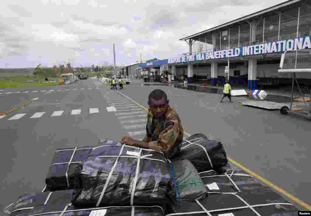 Vanuatu Mobile Force personnel ride on the back of a truck with supplies from the Australia airforce to be distributed days after Cyclone Pam in Port Vila, capital city of the Pacific island nation of Vanuatu March 19, 2015.