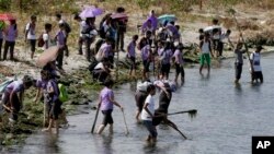 FILE- Students join other environmental activists in a coastal clean-up along the shores of Freedom Island to mark World Earth Day, April 22, 2015 at suburban Las Pinas, south of Manila, Philippines. 