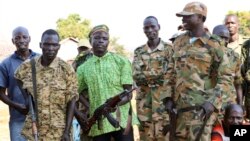 Government and opposition soldiers pose for a picture in the government barracks in Kajo Keji town, where 10 opposition soldiers were staying with the government troops in a makeshift soldier swap, in Kajo Keji county, South Sudan, Jan. 6, 2019.