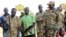 Government and opposition soldiers pose for a picture in the government barracks in Kajo Keji town, where 10 opposition soldiers were staying with the government troops in a makeshift soldier swap, in Kajo Keji county, South Sudan, Jan. 6, 2019.