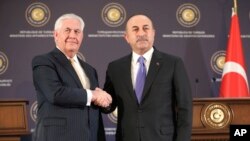 FILE - Turkey's Foreign Minister Mevlut Cavusoglu, right, shakes hands with U.S. Secretary of State Rex Tillerson after a joint news conference following their meeting in Ankara, Turkey, Feb. 16, 2018.