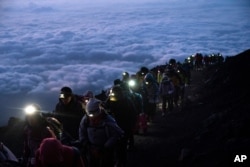 Sekelompok pendaki mendaki ke puncak Gunung Fuji sesaat sebelum matahari terbit, Selasa, 27 Agustus 2019, di Jepang.(Foto: AP)