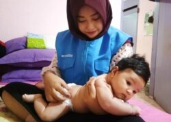 Seorang bidan yang tergabung dalam Sahabat Care sedang memberi layanan perawatan bayi di Palu. (Foto: Luluk Sindriani/Sahabat Care)