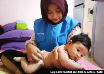 Seorang bidan yang tergabung dalam Sahabat Care sedang memberi layanan perawatan bayi di Palu. (Foto: Luluk Sindriani/Sahabat Care)