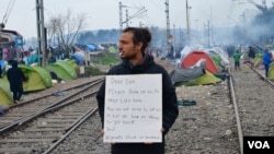 Unidentified man shares message of collective despair taking hold at makeshift refugee camp along Greek-Macedonian border, in Idomeni, Greece, March 16, 2016. (J. Dettmer/VOA)
