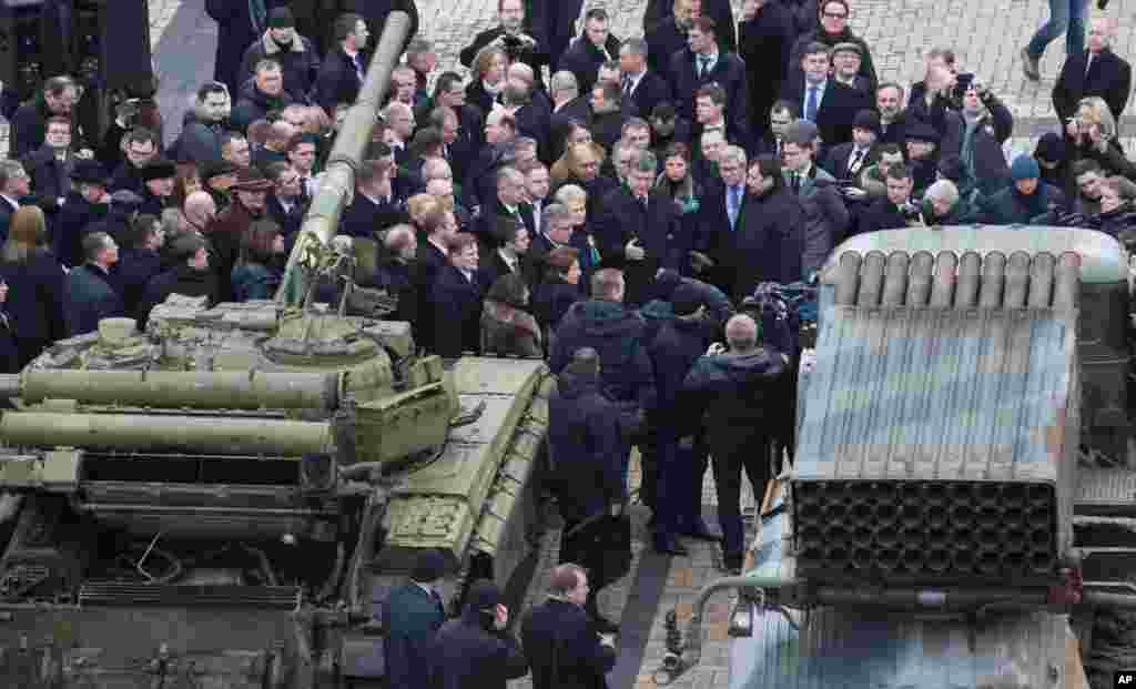 Ukrainian President Petro Poroshenko (center) speaks to foreign guests as a crowd examines Russian-made military gear reportedly seized by Ukrainian troops in eastern Ukraine, at an open-air exhibition in Kyiv, Ukraine, Feb. 22, 2015.
