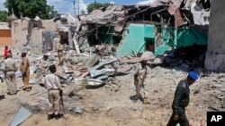 Des soldats somaliens regardent des maisons détruites à Mogadishu, Somalie, le 17 mai 2017.