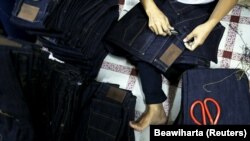 Seorang pekerja menjahit celana jeans di sebuah pabrik kecil di kawasan industri Cakung di Jakarta, 5 Mei 2015. (Foto: REUTERS/Beawiharta)