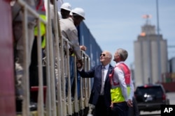 FILE - U.S. President Joe Biden and Chief Operating Officer of Lobito Atlantic Railway Nicolas Gregoire meet rail workers during a tour of the Lobito Port Terminal in Lobito, Angola, Dec. 4, 2024.