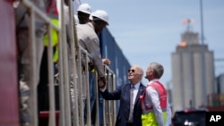 FILE - Presiden Joe Biden dan Kepala Operasional Lobito Atlantic Railway Nicolas Gregoire bertemu dengan para pekerja kereta api selama tur di Terminal Pelabuhan Lobito di Lobito, Angola, 4 Desember 2024. (Ben Curtis/AP)