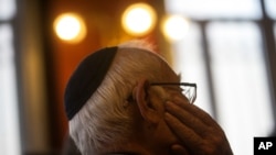 FILE - A man wearing a Jewish yarmulke listens during a news conference at the Royal Spanish Academy in Madrid, Spain, Feb. 20, 2018.