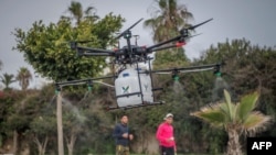 Un drone équipé de liquide désinfectant est survolé une rue de la capitale Rabat le 23 avril 2020, pour la désinfection comme moyen de lutte contre le coronavirus. (Photo par FADEL SENNA / AFP)