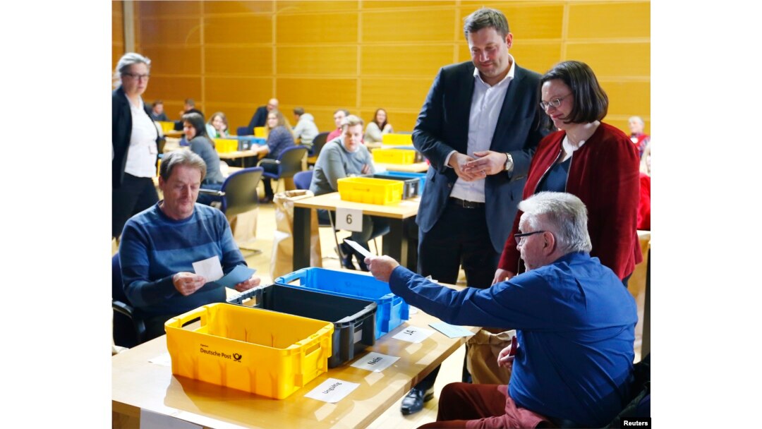 FILE - Andrea Nahles, right, and Lars Klingbeil of Social Democratic Party look on as party members count ballot papers of the voting for a possible coalition between the SPD and the Christian Democratic Union (CDU) in the SPD headquarters in Berlin, Germany, March 3, 2018.