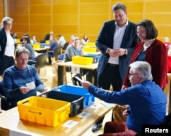FILE - Andrea Nahles, right, and Lars Klingbeil of Social Democratic Party look on as party members count ballot papers of the voting for a possible coalition between the SPD and the Christian Democratic Union (CDU) in the SPD headquarters in Berlin, Germany, March 3, 2018.