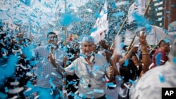 Confetti representing colors of the Argentine flag rain on demonstrators during a labor march in Buenos Aires, Argentina, March 7, 2017.
