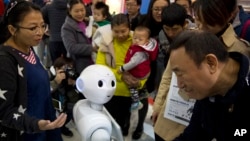 In this Friday, Oct. 21, 2016 photo, visitors crowd around Pepper, a companion robot from e-commerce giant Alibaba, during the World Robot Conference in Beijing. (AP Photo/Ng Han Guan)