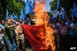 Supporters of the mostly Muslim Uighur minority and Turkish nationalists burn a Chinese flag during a protest to denounce China's treatment of ethnic Uighur Muslims during a deadly riot on July 2009 in Urumqi, in front of the Chinese consulate in Istanbul, on July 5, 2018.
