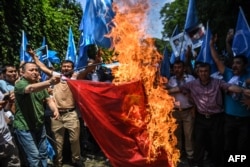 Supporters of the mostly Muslim Uighur minority and Turkish nationalists burn a Chinese flag during a protest to denounce China's treatment of ethnic Uighur Muslims during a deadly riot on July 2009 in Urumqi, in front of the Chinese consulate in Istanbul, on July 5, 2018.