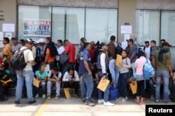Venezuelans who fled their homeland line up for temporary residence permits in Lima, Peru, Jan. 23, 2018.
