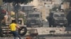 Seorang pengunjuk rasa Palestina membakar ban selama bentrokan dengan angkatan bersenjata Israel, selama operasi militer di kota Nablus, Tepi Barat, pada 9 Agustus 2022. (AP Photo/Majdi Mohammed)