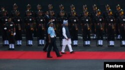 India's Prime Minister Manmohan Singh (C, in blue turban) inspects a guard of honour upon his arrival at the historic Red Fort during Independence Day celebrations in Delhi, August 15, 2013.