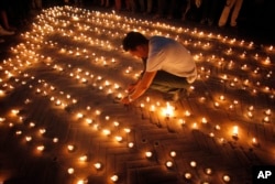Nepalese people light candles in memory of those who died in last year's devastating earthquake in Basantapur Durbar Square in Kathmandu, Nepal, April 24, 2016.