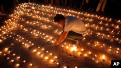 Nepalese people light candles in memory of those who died in last year's devastating earthquake in Basantapur Durbar Square in Kathmandu, Nepal, April 24, 2016. 