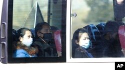 People wear masks as they ride on a public bus in Pyongyang, North Korea, Feb. 26, 2020. 