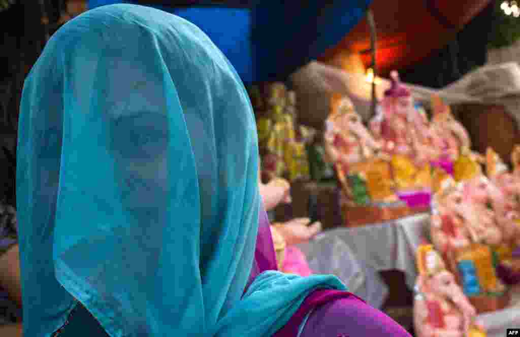 An Indian artist stands near Ganesh idols for sale on the first day of the Ganesh Chaturthi festival in New Delhi. The Hindu festival is celebrating the rebirth of the God Lord Ganesha and culminates on September 19.