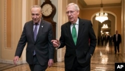 Senate Majority Leader Mitch McConnell, R-Ky., and Senate Minority Leader Chuck Schumer, D-N.Y., left, walk to the chamber after collaborating on an agreement on a two-year, nearly $400 billion budget deal.